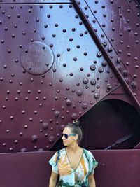 Woman standing against metal bridge