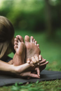 Low section of woman doing yoga in garden