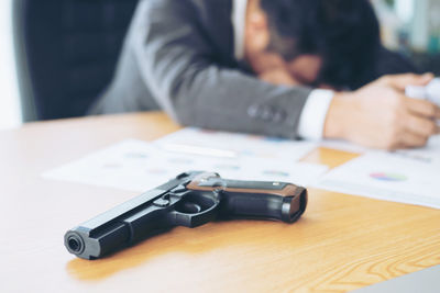 Close-up of man using smart phone on table