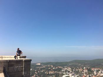 Man in city against clear sky