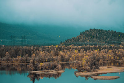 Scenic view of lake by trees against sky