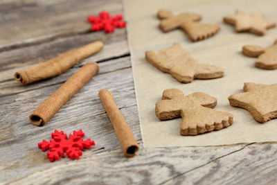 Cookies with cinnamon and artificial snowflakes on wooden table