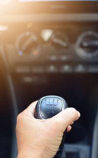 Cropped hand of person holding gearshift while driving car