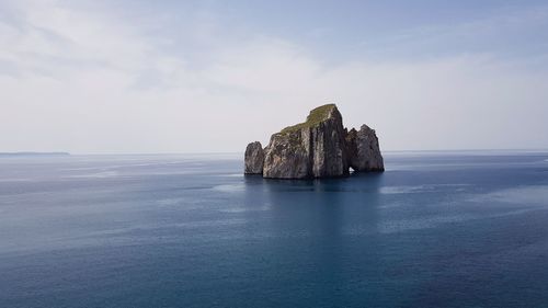 Rock formations in sea against sky