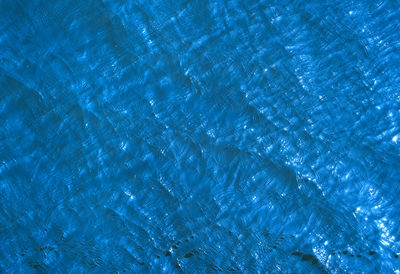 Water of blue color with solar patches of light. top view