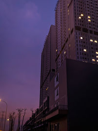 Low angle view of illuminated buildings against sky at dusk