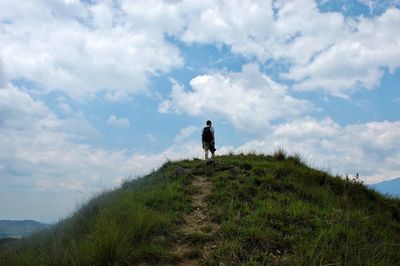 Man walking on mountain against sky