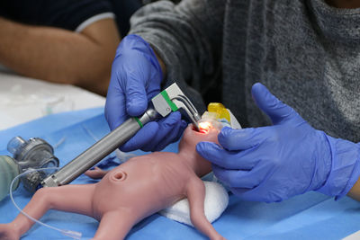 Midsection of doctor working on baby dummy
