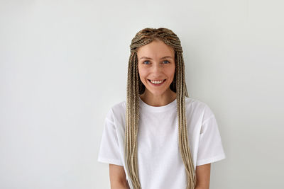 Portrait of a smiling young woman against white background