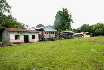 Houses on field against clear sky