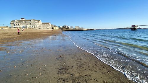 Scenic view of beach against clear blue sky