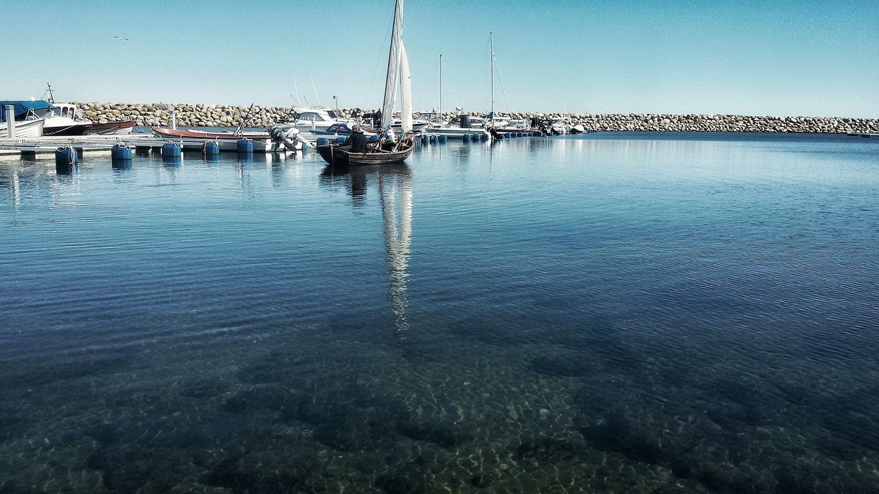 water, nautical vessel, reflection, clear sky, moored, boat, lake, transportation, wooden post, waterfront, blue, tranquility, rippled, mode of transport, tranquil scene, river, sailboat, nature, sea, outdoors