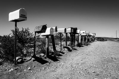 Mailboxes in a row by field against sky