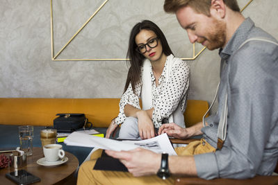 Business colleagues analyzing documents at hotel lobby