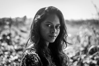 Portrait of beautiful young black woman standing on field