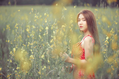 Young woman looking away in field