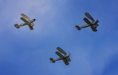 Low angle view of airplane against blue sky