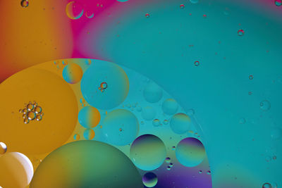 Top view oil bubbles drop on the water with colorful background, macro photography concept