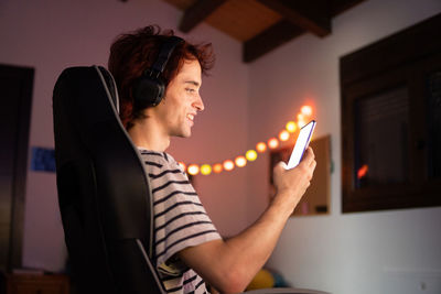 Man using mobile phone while sitting in darkroom