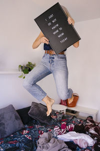 Low section of woman standing on bed