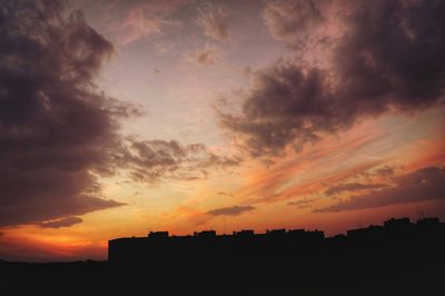 Silhouette of built structure against cloudy sky