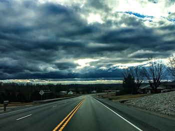 Empty road against cloudy sky