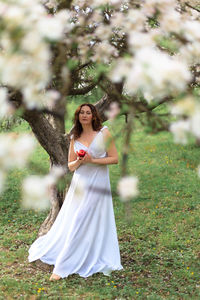 Portrait of smiling young woman standing on field