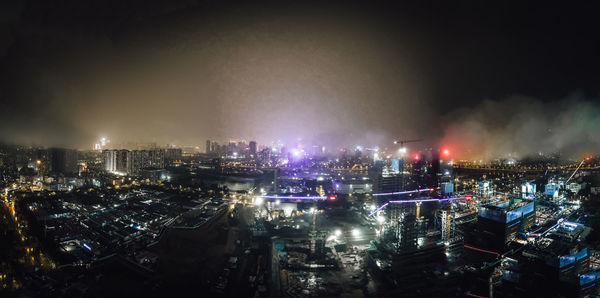 High angle view of illuminated city against sky at night