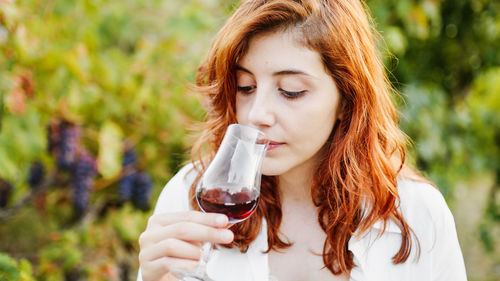 Agronomist smells red wine among the vineyards during the harvest