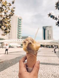 Midsection of person holding ice cream in city