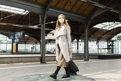 Full length portrait of woman standing in corridor