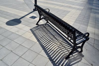 High angle view of empty bench on sidewalk