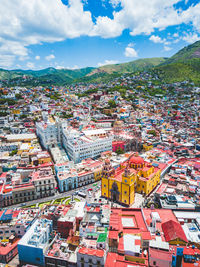 Aerial view of townscape against cloudy sky