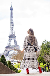 Rear view of woman with tower in background