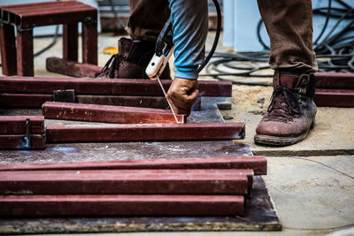 Low section of man working on metal