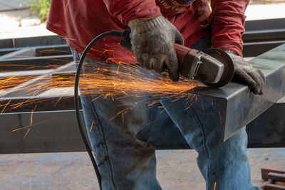 Midsection of man grinding metal