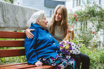 Grandparents day, reunited family, togetherness. senior old grandma hugs granddaughter outdoors