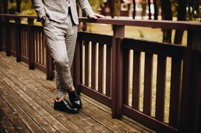 Low section of well-dressed man standing in park