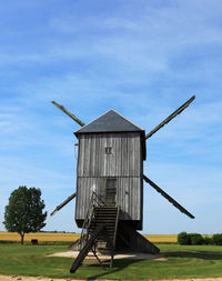 Traditional windmill on field against sky