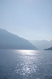 Scenic view of sea and mountains against clear sky