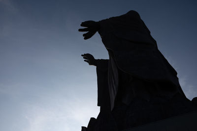 Low angle view of silhouette statue against sky