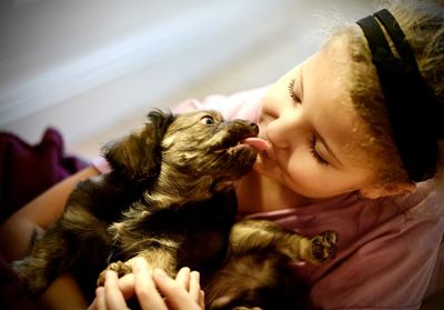 Young woman with dog, geting a kiss