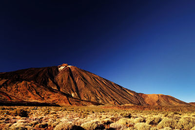 Scenic view of rocky mountain at el teide national park against clear blue sky