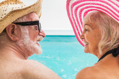 Side view of smiling friends at beach