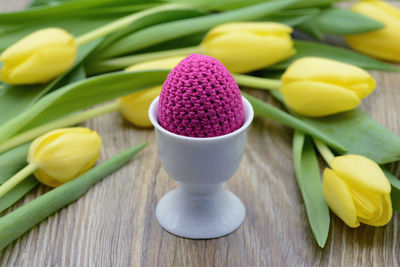 Close-up of eggcup and tulips on table