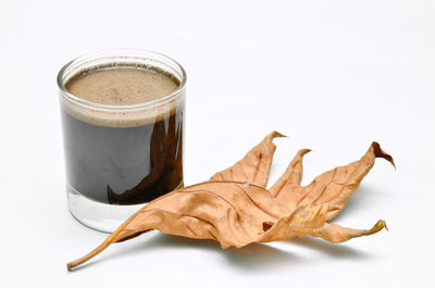Close-up of coffee cup on table against white background