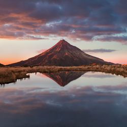 Reflection of mountains on lake against sky during sunset