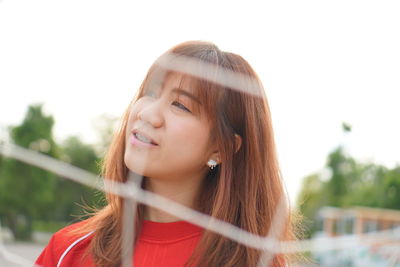 Portrait of a beautiful young woman against sky