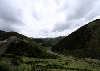 Scenic view of mountains against cloudy sky