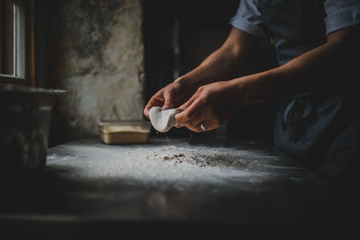 Midsection of man preparing food in kitchen